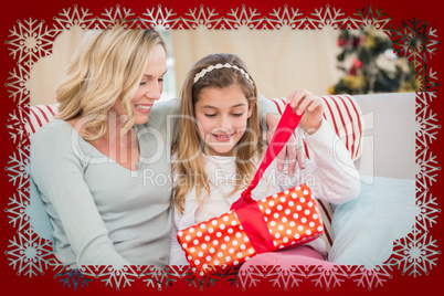 Composite image of cute little girl sitting on couch opening gif