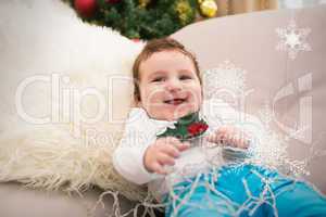 Composite image of cute baby boy on the couch at christmas