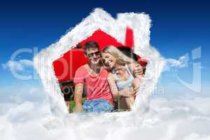 Composite image of smiling couple sitting on the grass having pi