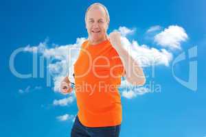 Composite image of mature man in orange tshirt cheering holding