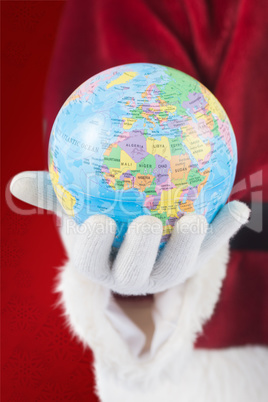 Composite image of santa has a globe in his hand Composite image of santa has a globe in his hand