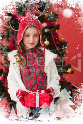 Composite image of festive little girl holding gift