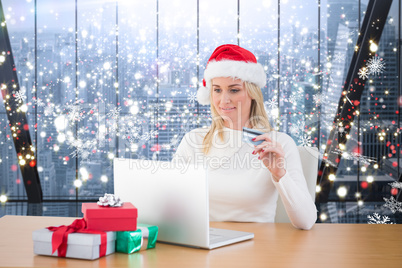 Composite image of festive blonde shopping online