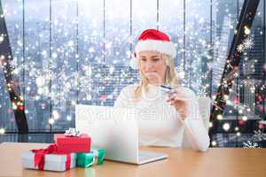 Composite image of festive blonde shopping online