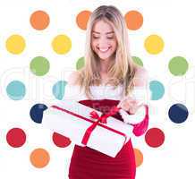 Composite image of pretty santa girl opening gift