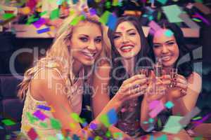 Composite image of happy friends drinking shots together