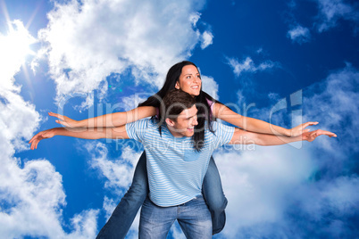 Composite image of young man giving girlfriend a piggyback ride