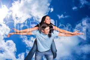 Composite image of young man giving girlfriend a piggyback ride