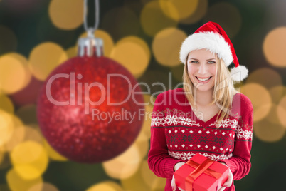 Composite image of woman smiling with present in hands