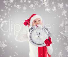 Composite image of festive blonde holding a clock