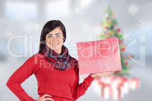 Composite image of smiling brunette showing red gift bag