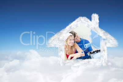 Composite image of affectionate couple painting a room