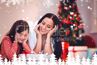 Composite image of festive mother and daughter smiling at gift