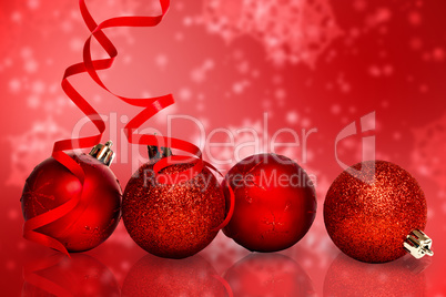 Composite image of four red christmas ball decorations