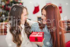 Composite image of daughter giving her mother a christmas presen
