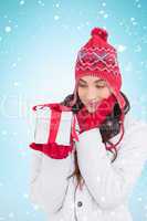 Composite image of content brunette in winter clothes holding gi