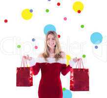 Composite image of pretty santa girl holding gift bags