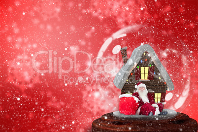 Composite image of santa sitting in snow globe