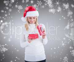 Composite image of festive blonde opening christmas gift