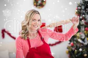 Composite image of festive blonde making christmas cookies