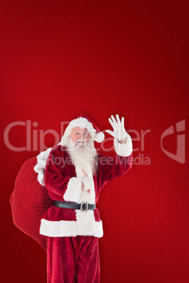 Composite image of santa waves to the camera
