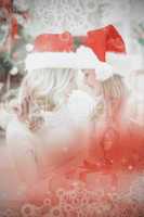 Composite image of festive mother and daughter smiling at each o