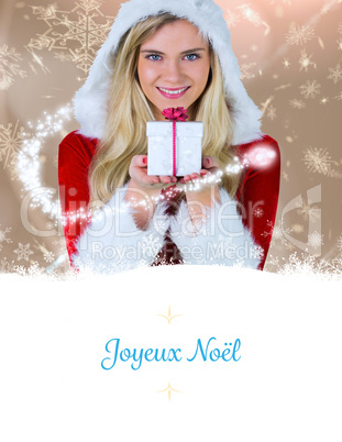 Composite image of pretty girl in santa outfit holding gift Composite image of pretty girl in santa outfit holding gift