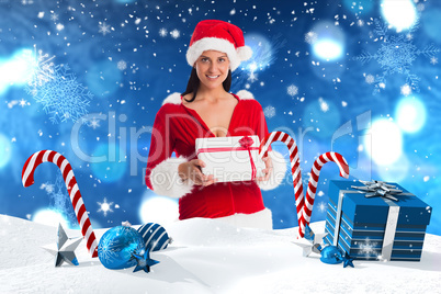 Composite image of woman smiling with christmas present