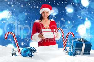 Composite image of woman smiling with christmas present