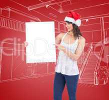 Composite image of pretty girl in santa hat holding poster