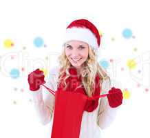 Composite image of happy festive blonde with shopping bag