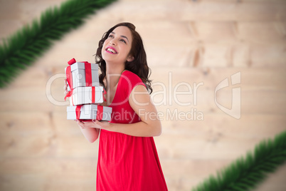 Composite image of stylish brunette in red dress holding pile of