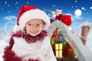 Composite image of cute little girl wearing santa hat and tinsel