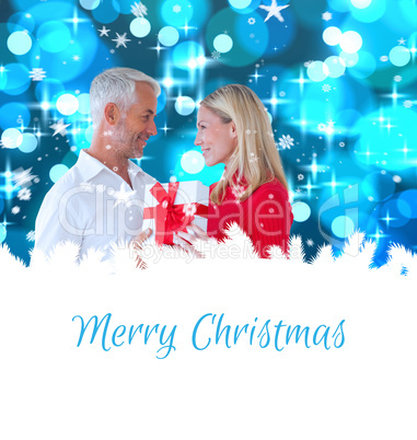 Composite image of loving couple with gift