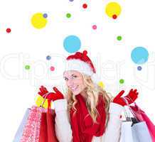 Composite image of happy festive blonde with shopping bags