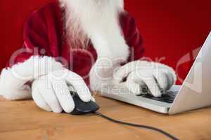 Composite image of santa surfs on the internet