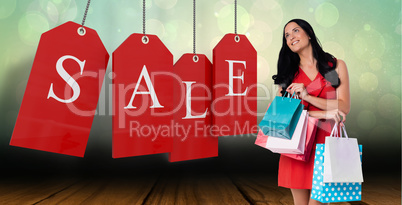 Composite image of woman standing with shopping bags