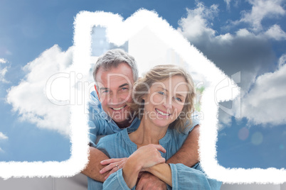 Composite image of content man hugging his wife on the couch