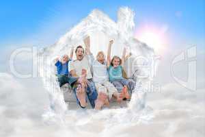 Composite image of family sitting on a couch and raising arms