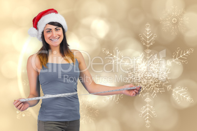 Festive fit brunette measuring her waist