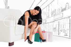 Composite image of woman sitting with shopping bags