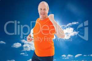 Composite image of mature man in orange tshirt cheering holding