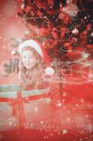 Composite image of festive little girl sitting in large gift