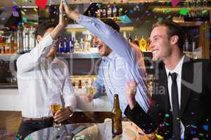 Composite image of handsome friends having a drink together