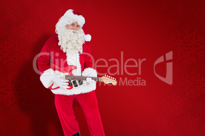 Composite image of happy santa playing electric guitar