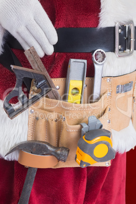 Composite image of father christmas is wearing a tool belt