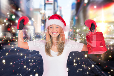 Composite image of festive blonde punching with boxing gloves