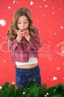 Composite image of festive little girl blowing over hands