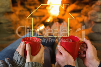 Composite image of hands with red coffee cups in front of lit fi