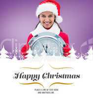 Composite image of festive brunette holding clock